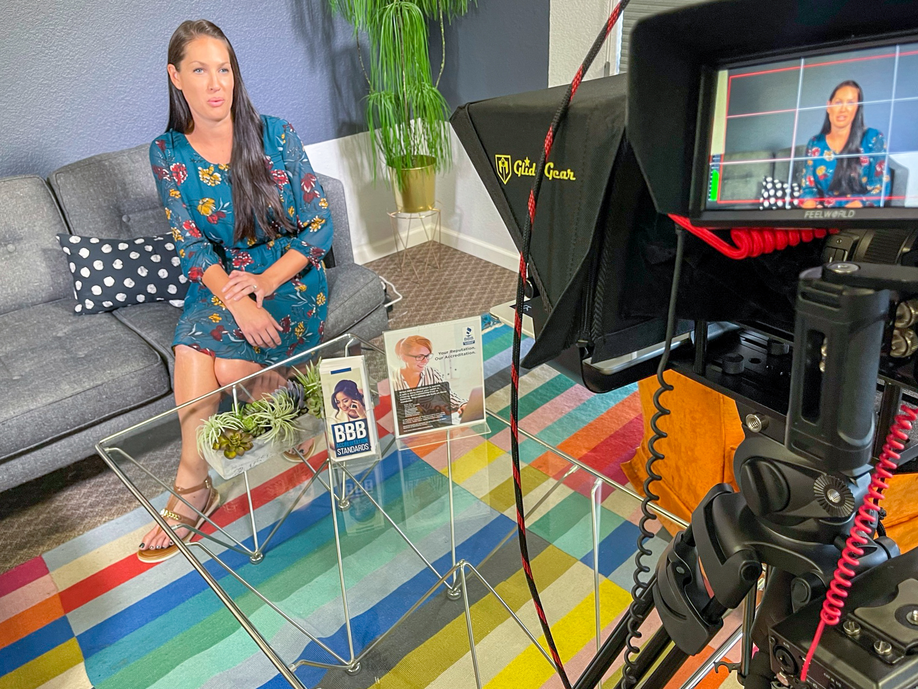 woman being filmed for corporate interview in office with camera and monitor visible