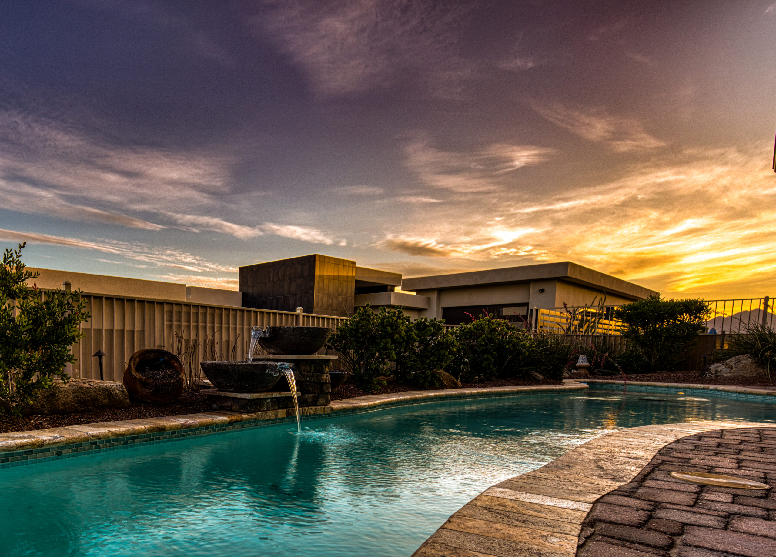 Backyard pool with waterfall feature during golden hour sunset in Lake Havasu