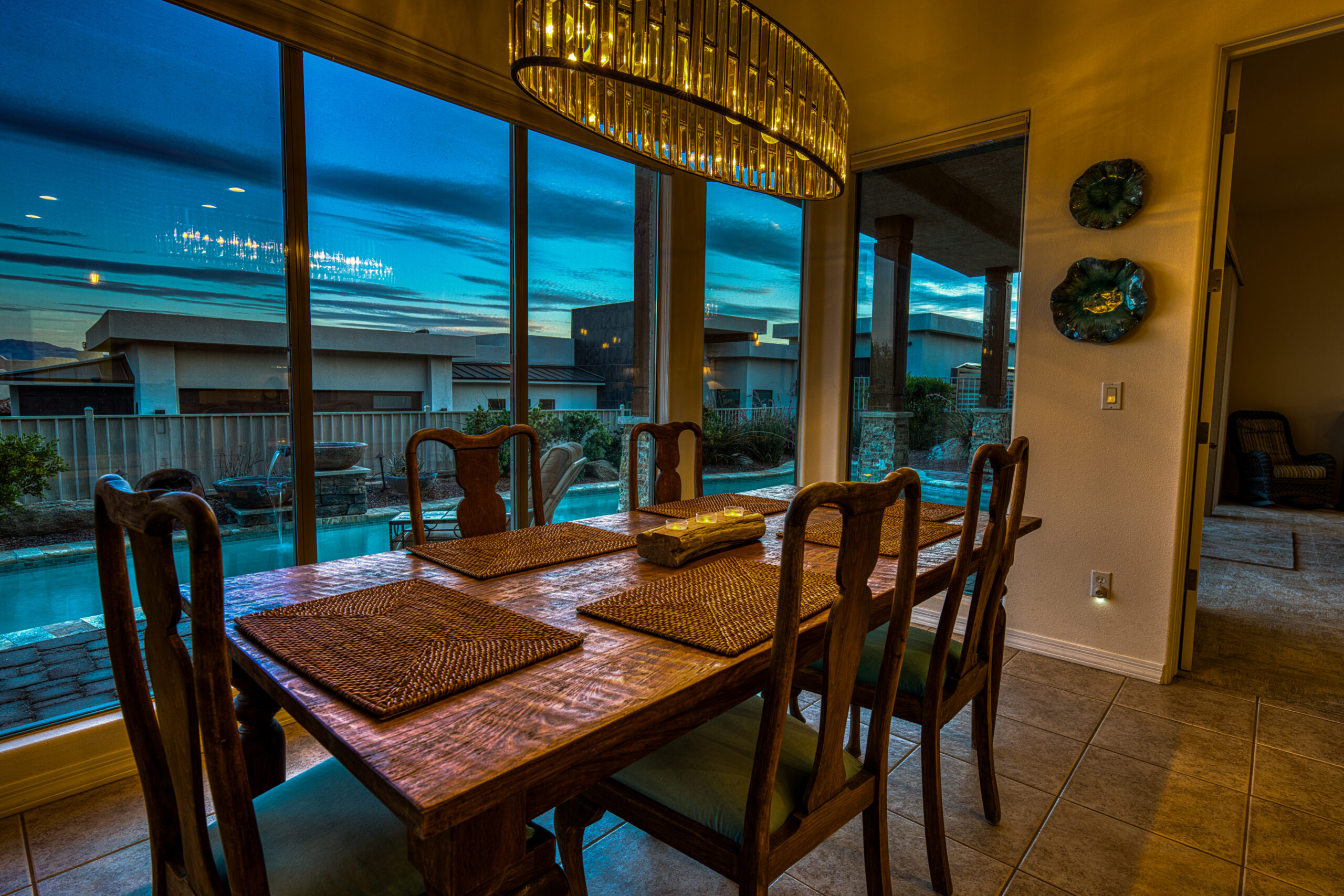 Dining room interior with chandelier and pool view at twilight in Lake Havasu home