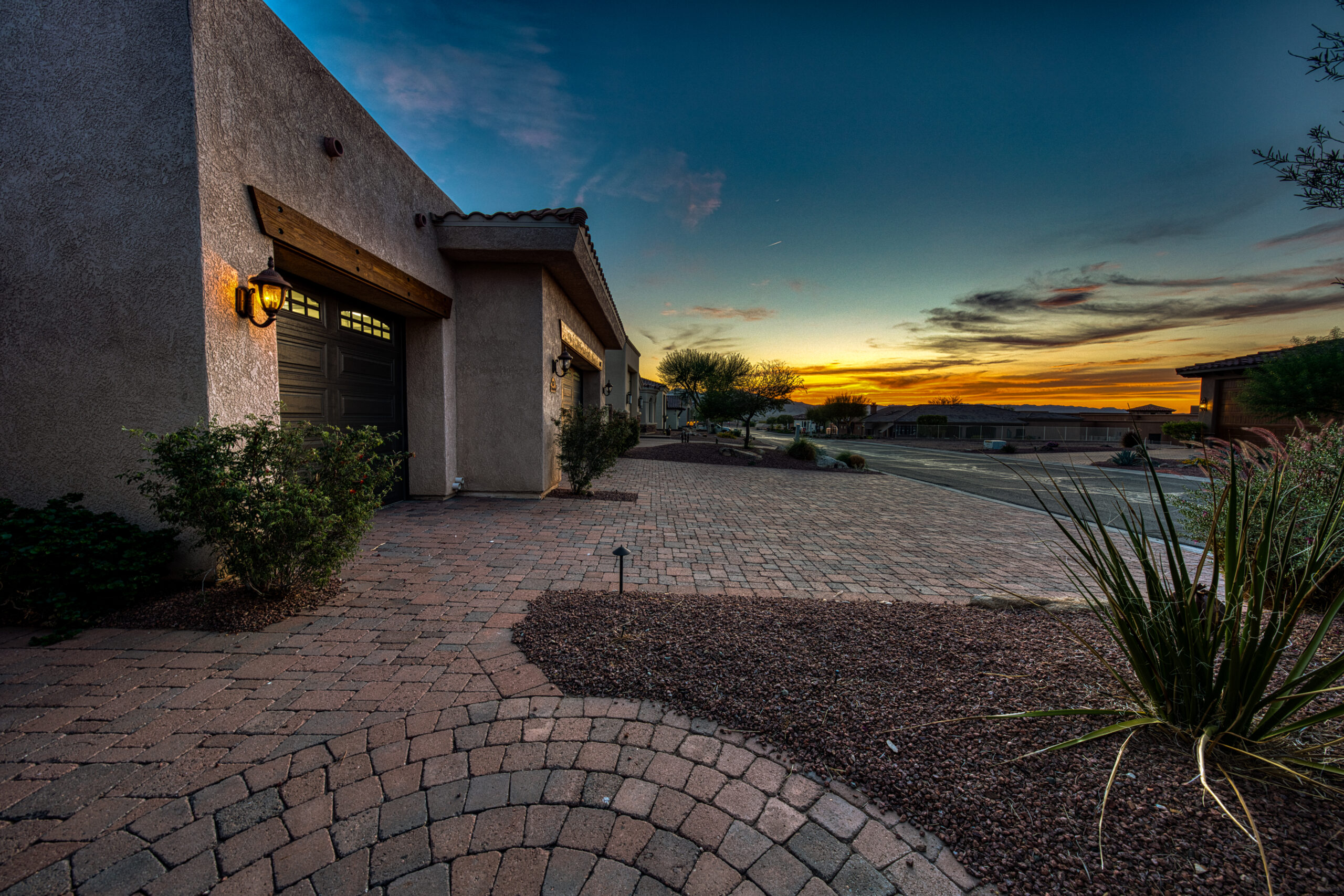 Driveway and front entry of home at twilight with desert landscaping in Lake Havasu