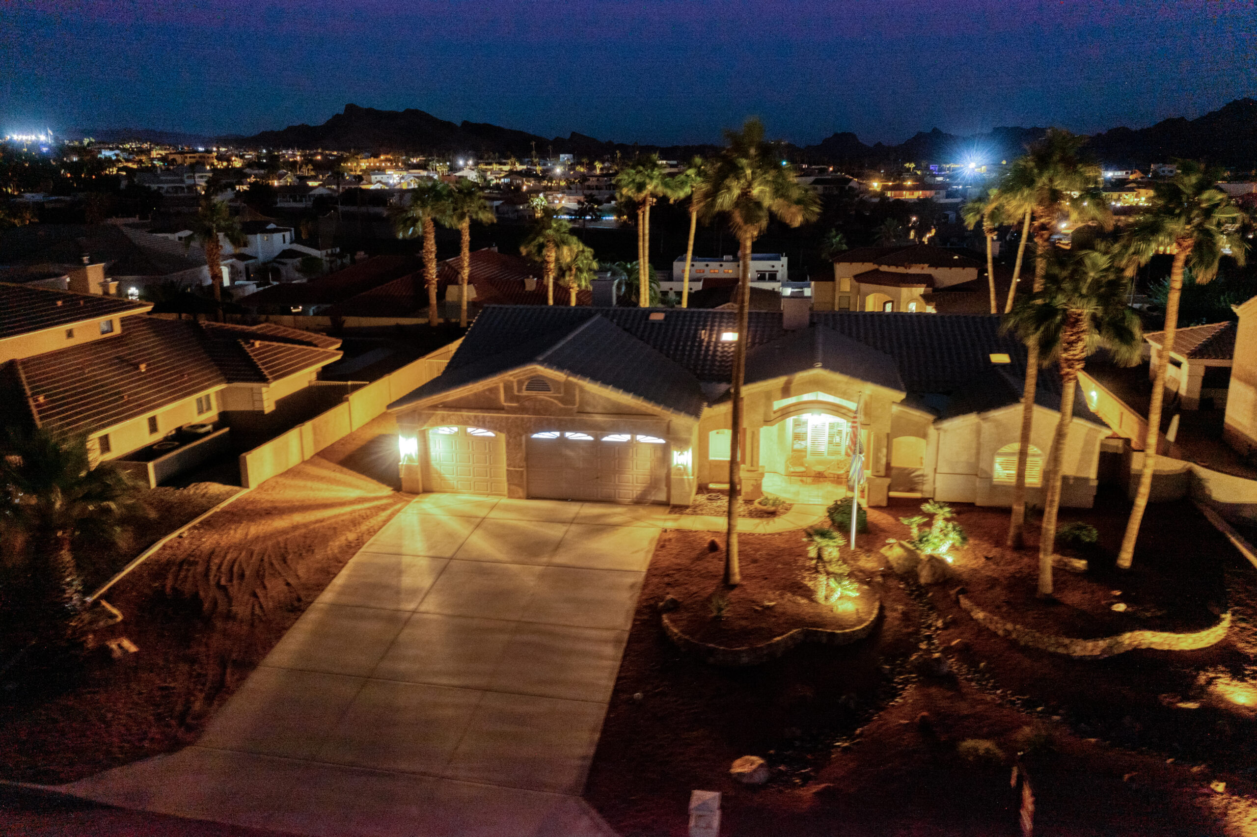 Twilight aerial of driveway and garage with desert landscaping at a Lake Havasu luxury home