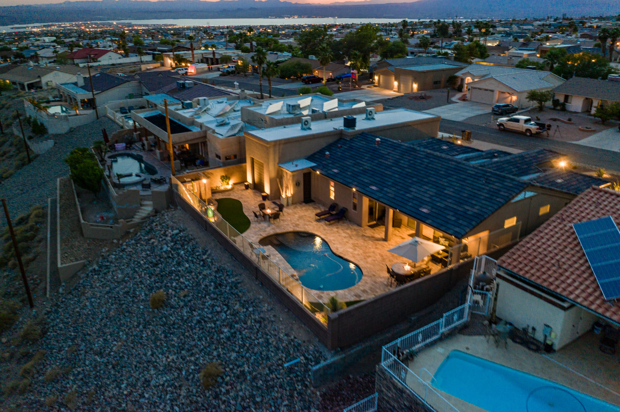 Drone view of home at dusk with landscape lighting in Lake Havasu