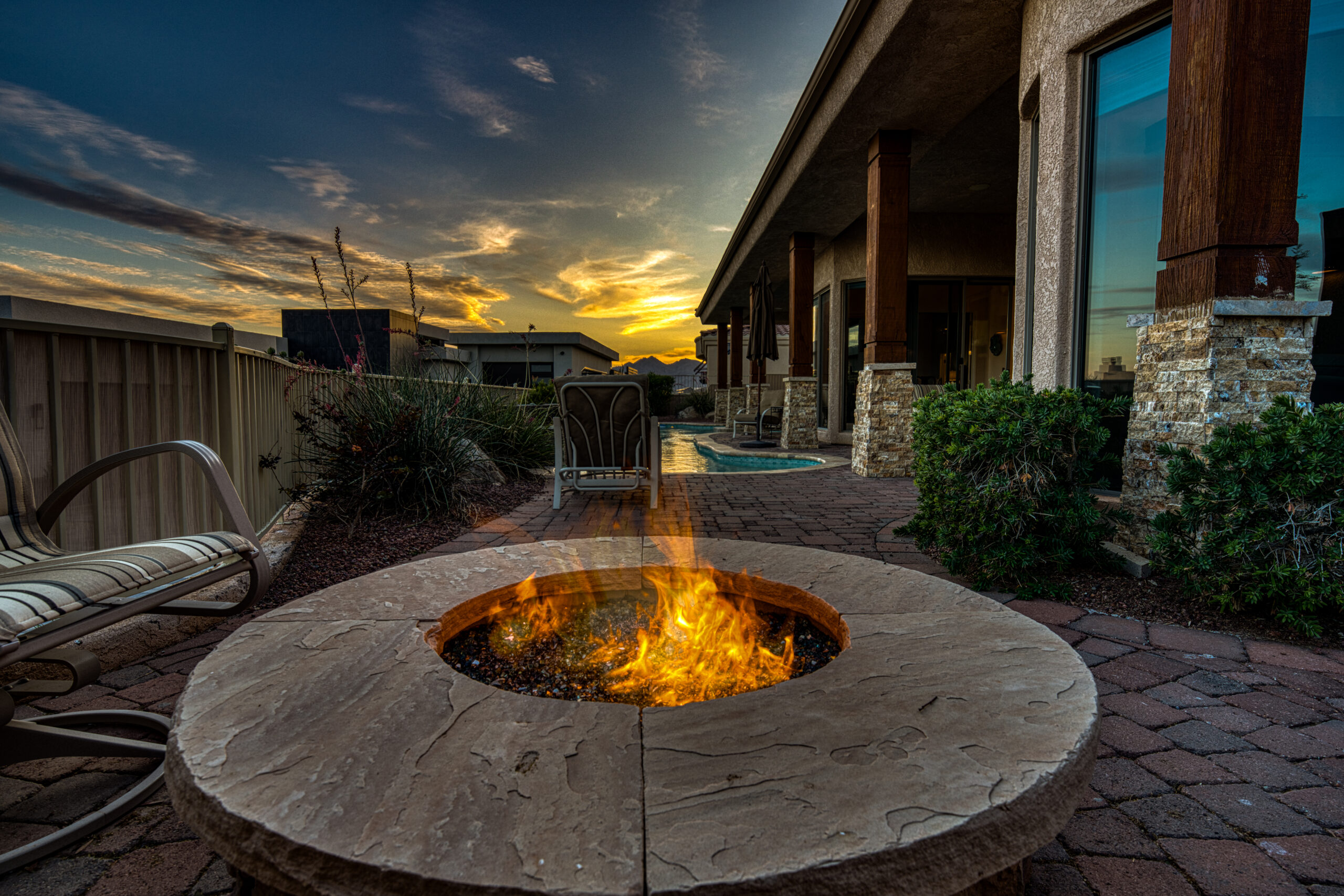 Outdoor patio firepit with seating and sunset sky in Lake Havasu backyard
