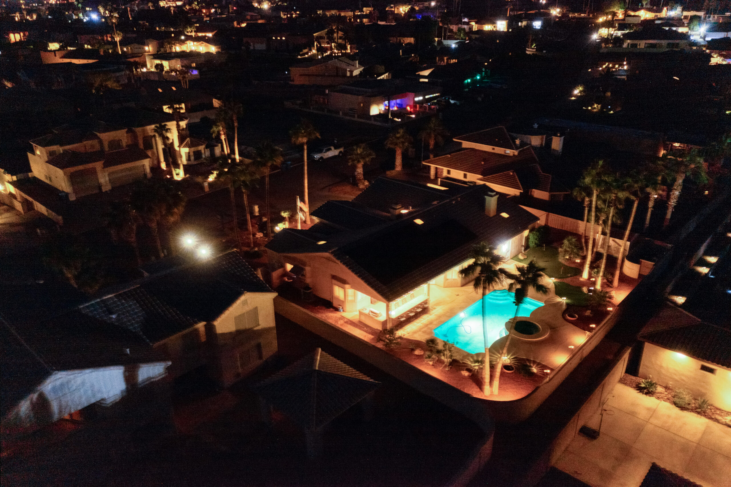 Front yard with palm trees and landscape lighting at dusk in a Lake Havasu luxury home