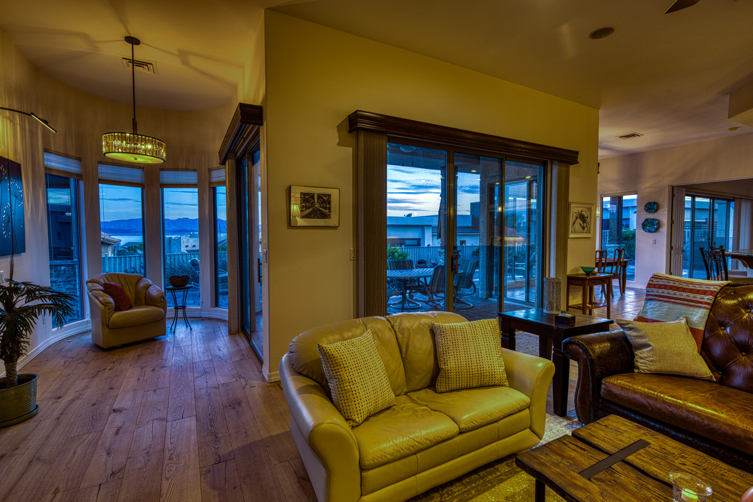 Luxury living room interior at twilight with large windows and patio view in Lake Havasu City