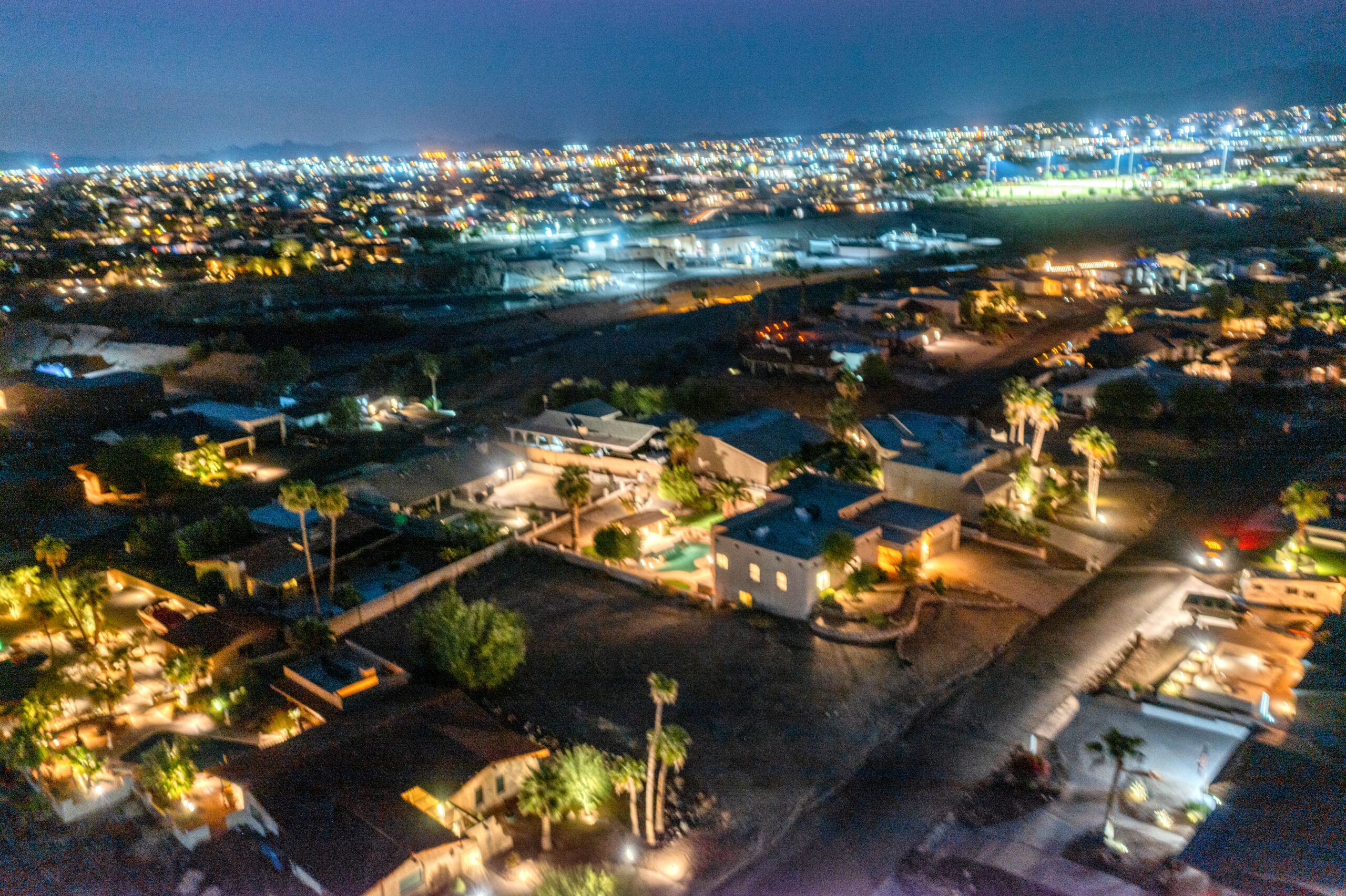 Luxury backyard pool with accent lighting and outdoor seating at night in Lake Havasu home