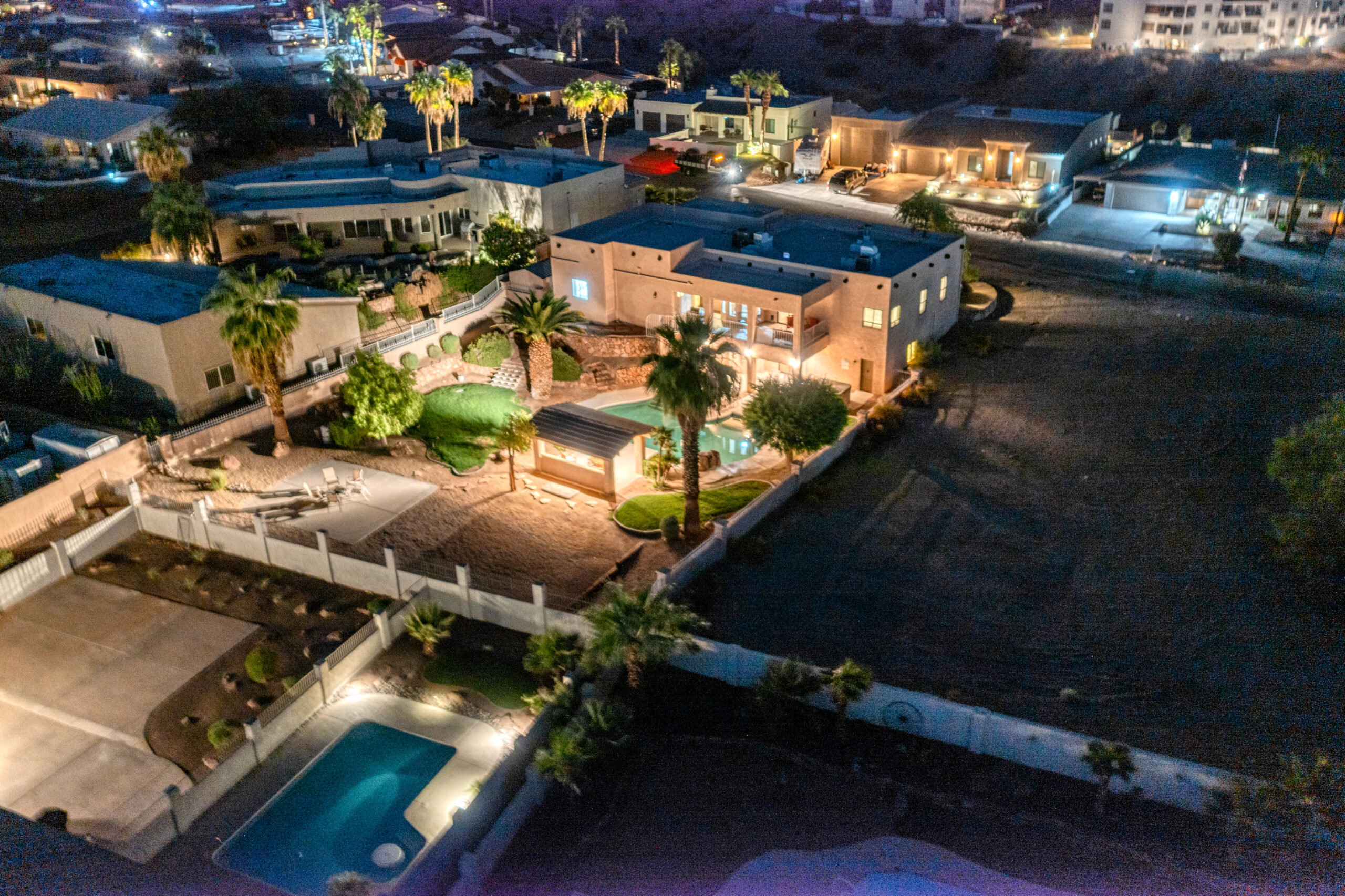 Luxury backyard pool with ambient lighting and outdoor living space at night in Lake Havasu