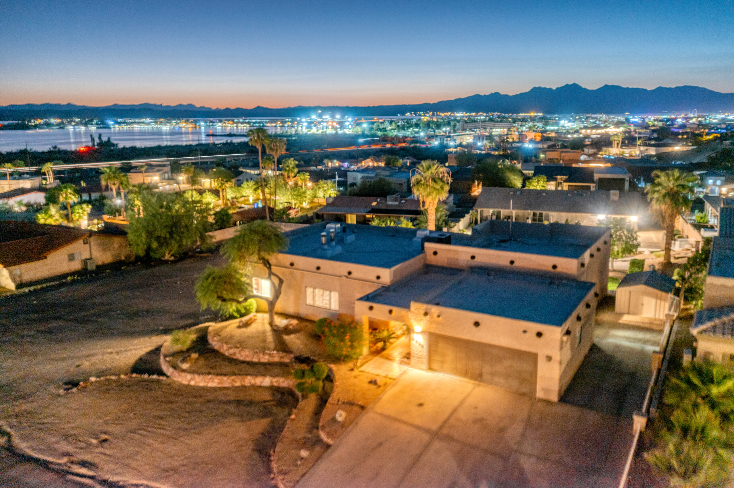Lake Havasu waterfront neighborhood sunset aerial with mountain views and residential homes