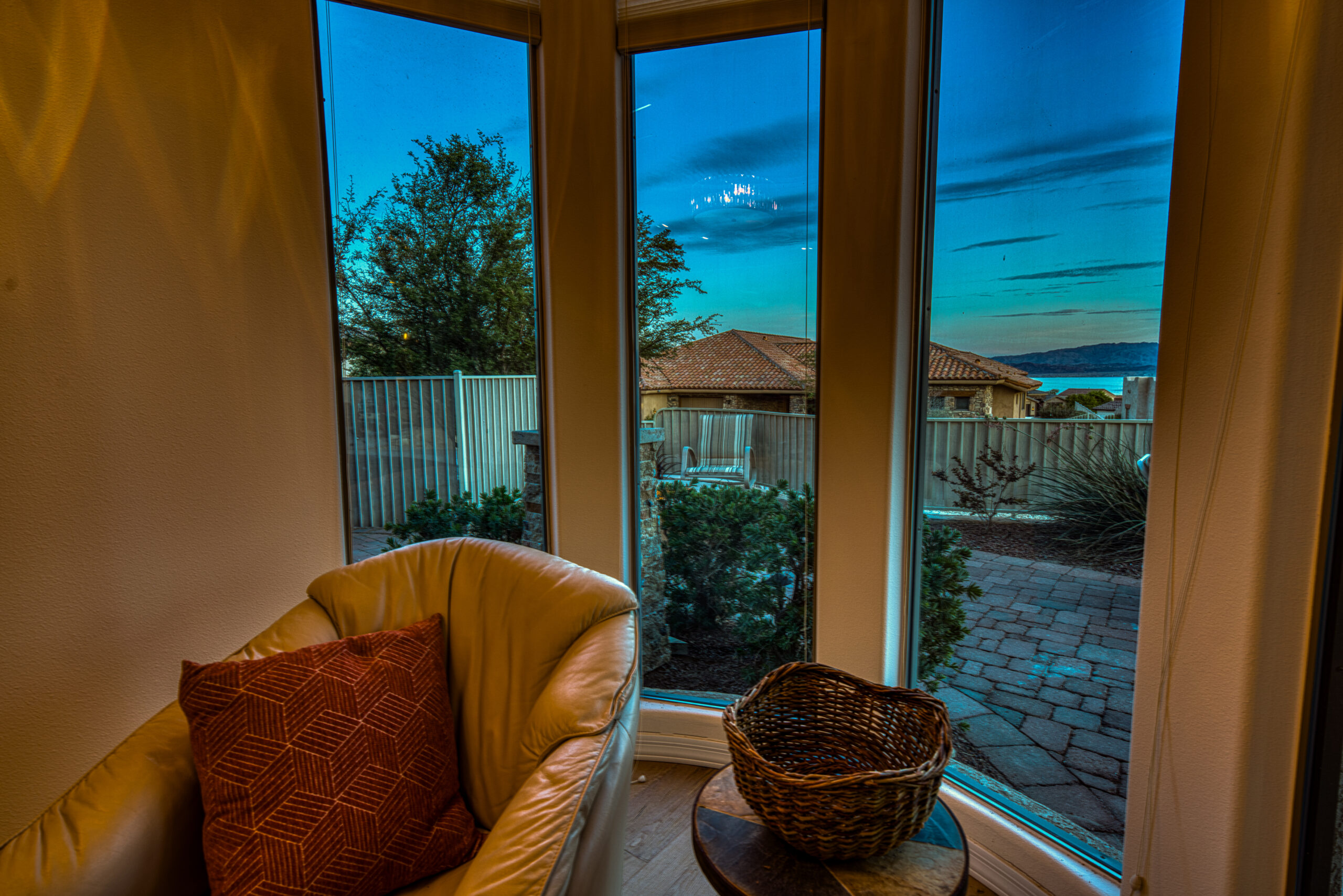 Window seating nook with chair and patio view at twilight in Lake Havasu home