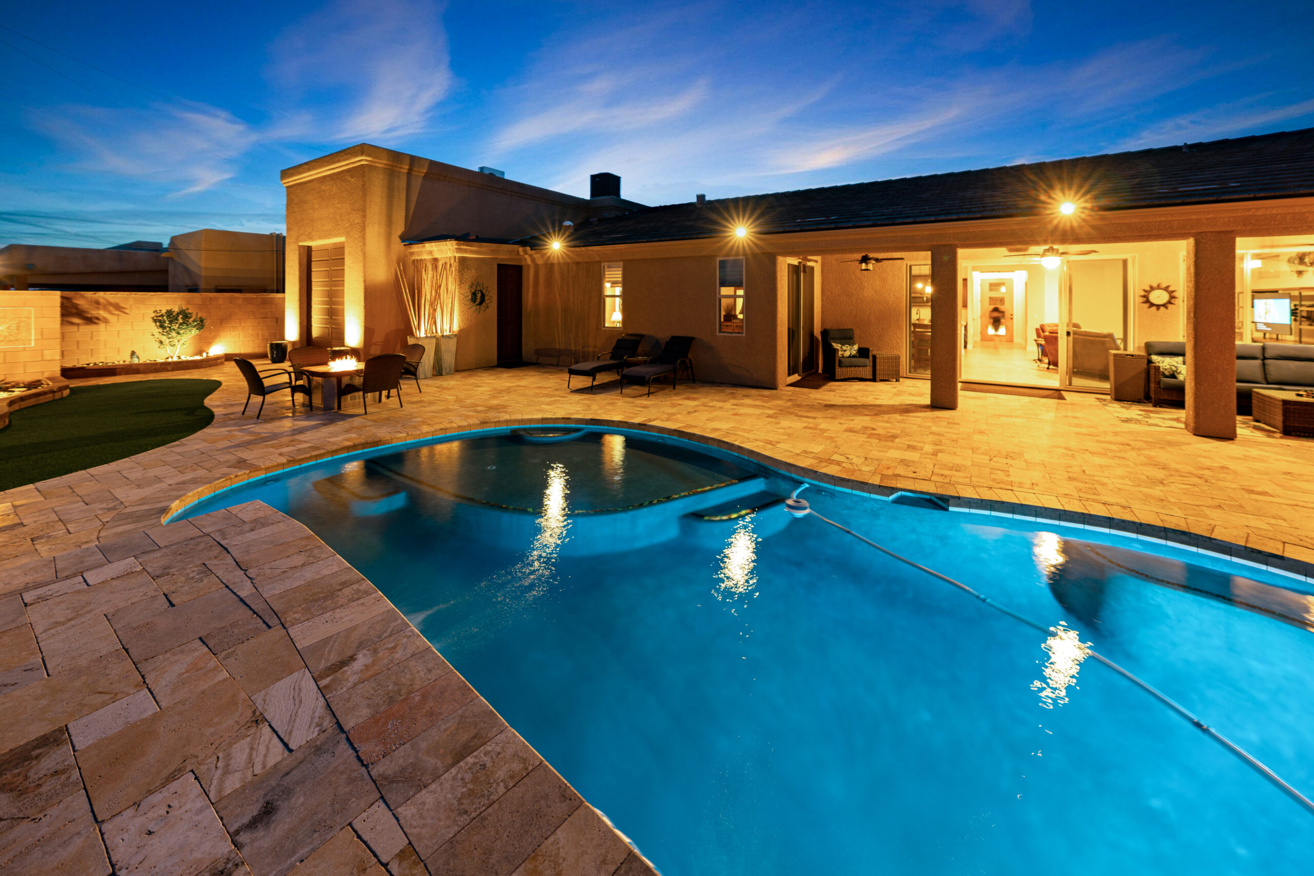 Luxury backyard pool and patio at night with ambient lighting in Lake Havasu