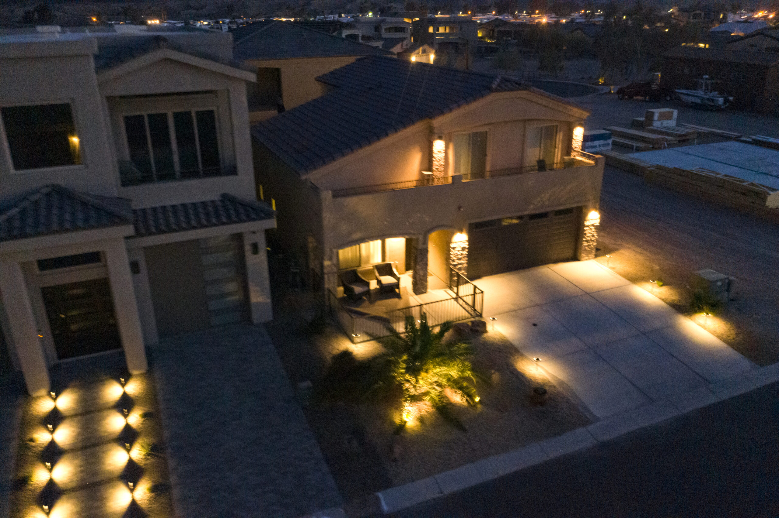 Luxury home exterior at night with driveway and landscape lighting in Lake Havasu
