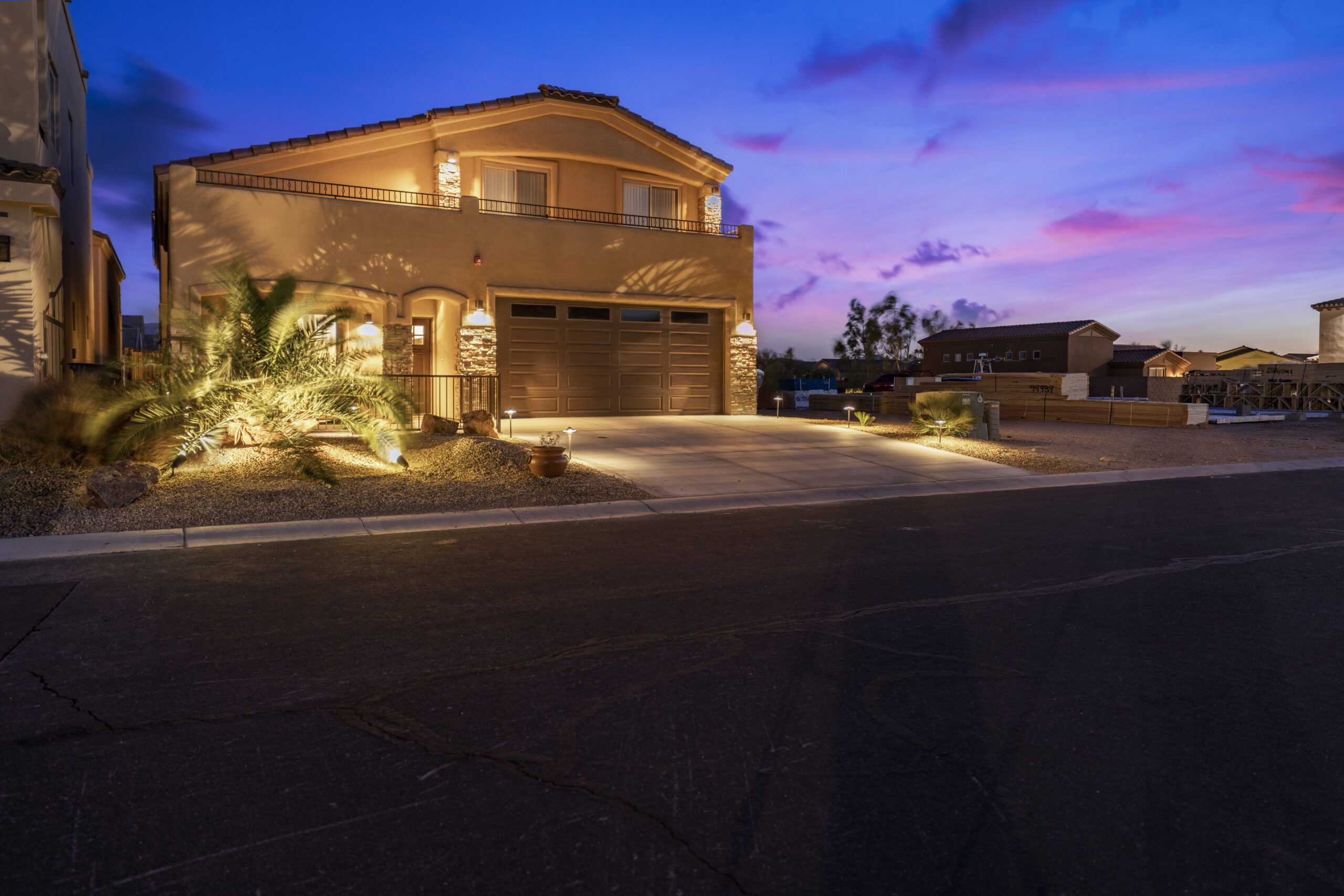 Luxury home exterior at sunset with warm lighting and desert landscaping