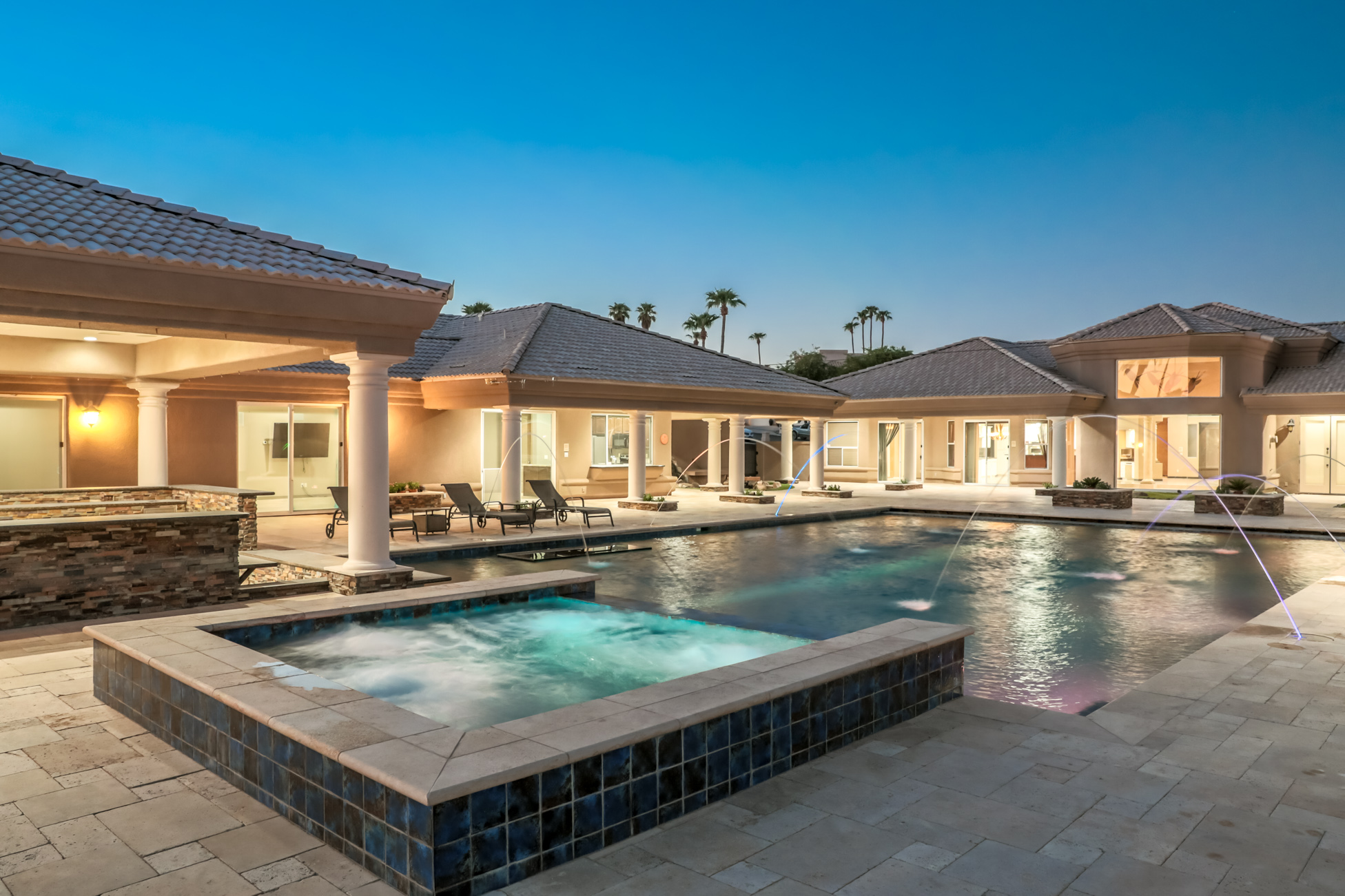 Luxury backyard pool and spa with water features at twilight in Lake Havasu